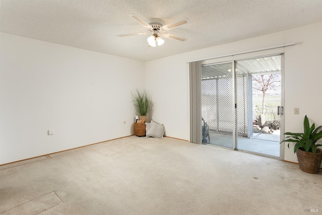 carpeted empty room featuring ceiling fan and a textured ceiling