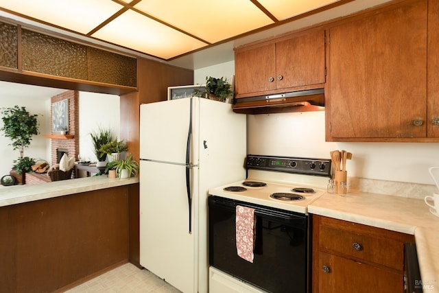 kitchen with a brick fireplace, white refrigerator, and range with electric cooktop