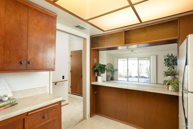 kitchen featuring ceiling fan, light carpet, and refrigerator