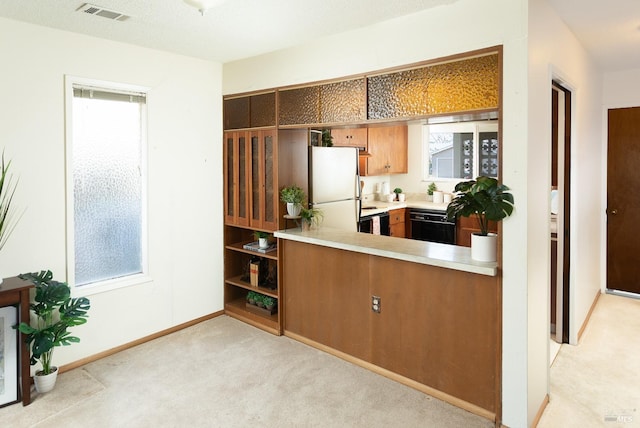 kitchen featuring dishwasher, a wealth of natural light, white refrigerator, and light carpet