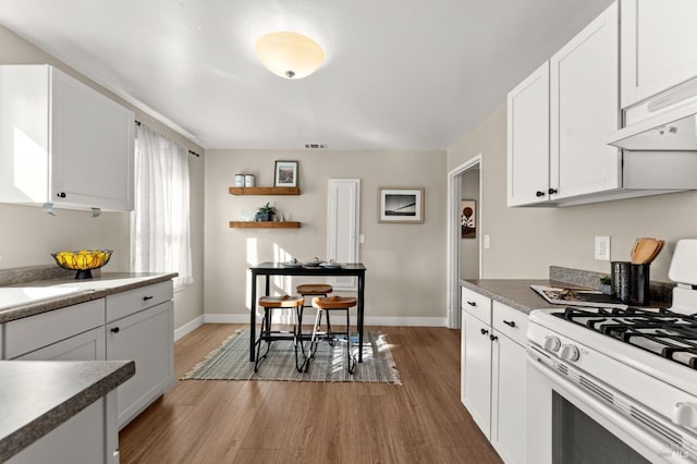 kitchen featuring white cabinetry and white gas stove