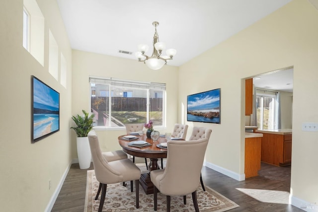 dining area featuring dark hardwood / wood-style flooring and an inviting chandelier