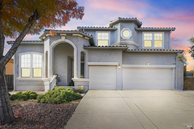 mediterranean / spanish-style house with a garage