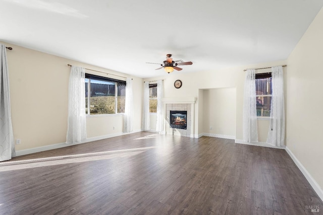 unfurnished living room with ceiling fan, dark hardwood / wood-style floors, and a tile fireplace