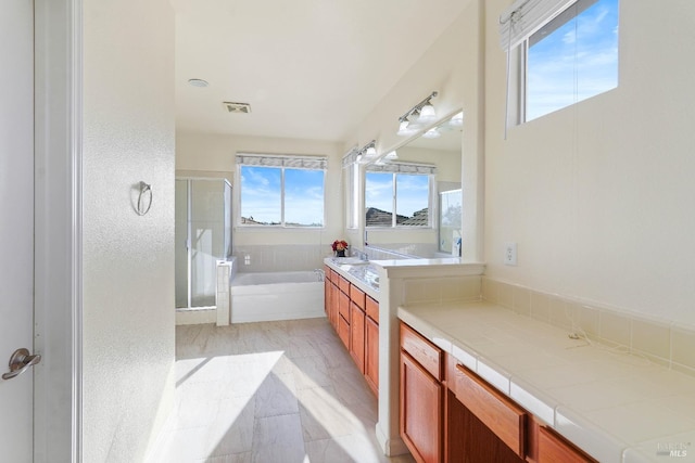 bathroom featuring shower with separate bathtub and vanity