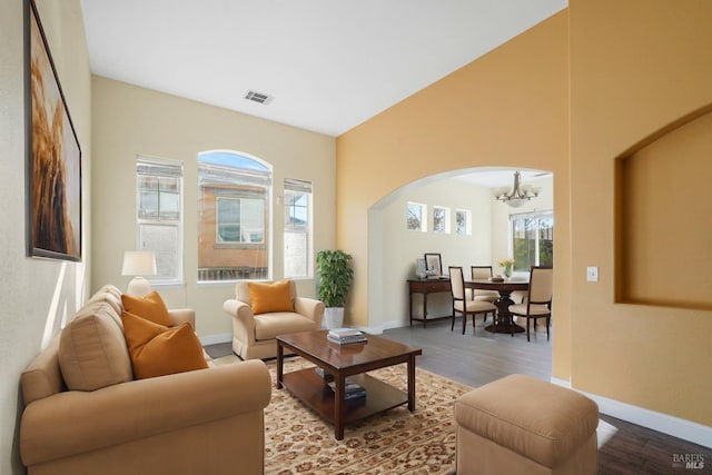 living room featuring wood-type flooring, plenty of natural light, and a chandelier