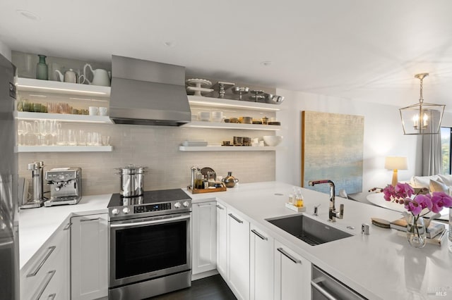 kitchen with appliances with stainless steel finishes, decorative light fixtures, white cabinetry, sink, and island exhaust hood