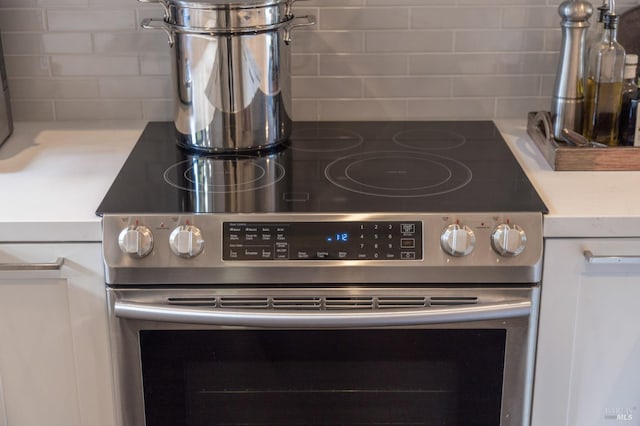 details featuring decorative backsplash and electric range