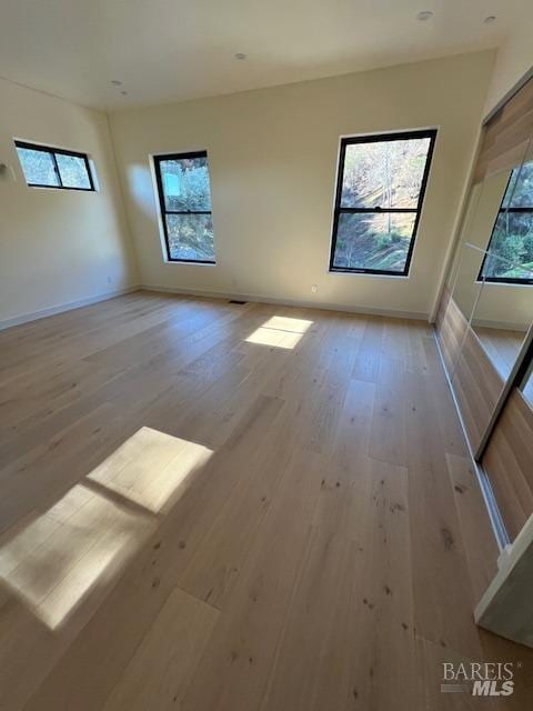 empty room with light hardwood / wood-style flooring