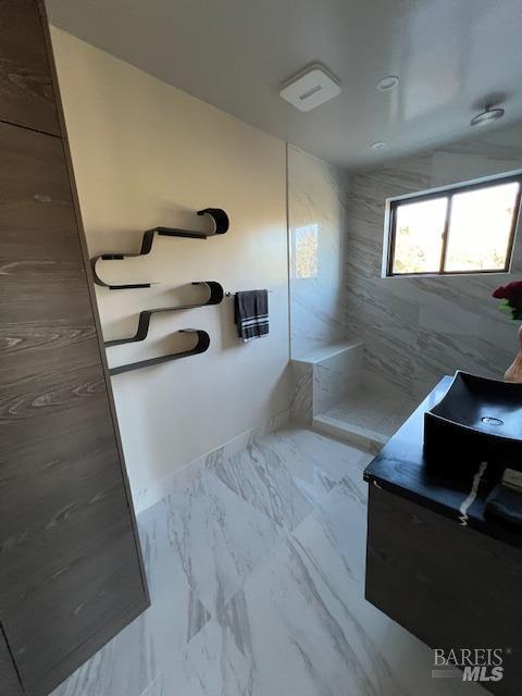 bathroom featuring a shower and vanity