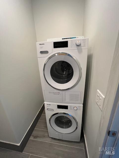 washroom featuring stacked washer and clothes dryer