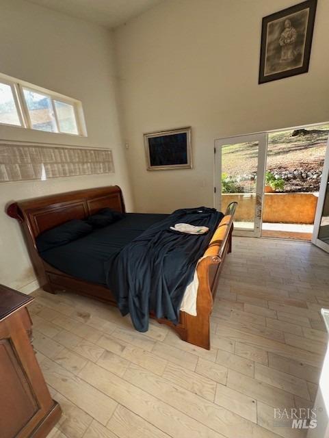 bedroom featuring light hardwood / wood-style flooring and a wall unit AC