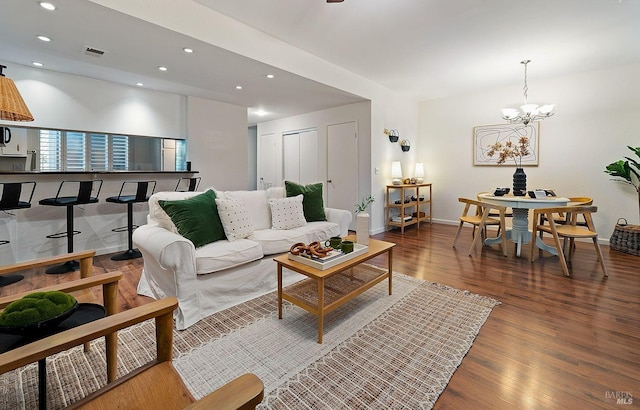 living room with dark wood-type flooring and a chandelier