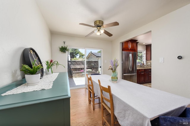 interior space with tasteful backsplash, sink, stainless steel fridge, light wood-type flooring, and ceiling fan