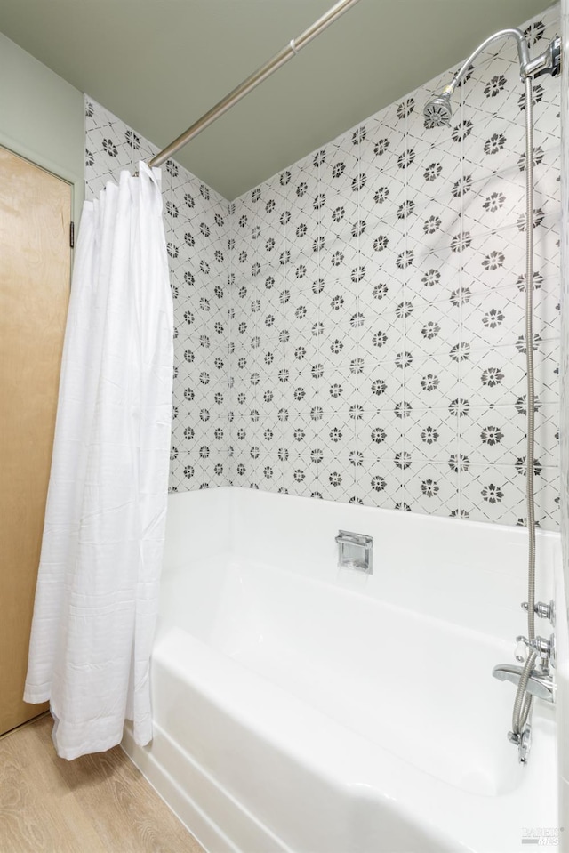 bathroom featuring hardwood / wood-style flooring and shower / tub combo with curtain