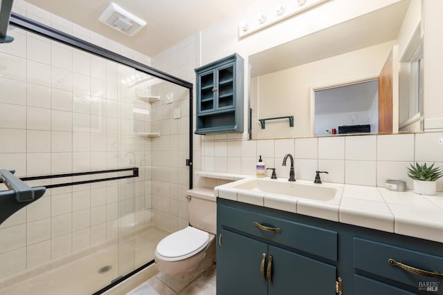 bathroom with toilet, tasteful backsplash, tile patterned flooring, an enclosed shower, and vanity