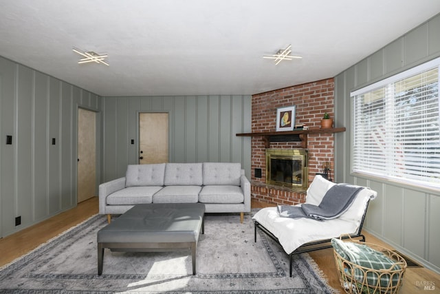 living room with light wood-type flooring and a brick fireplace