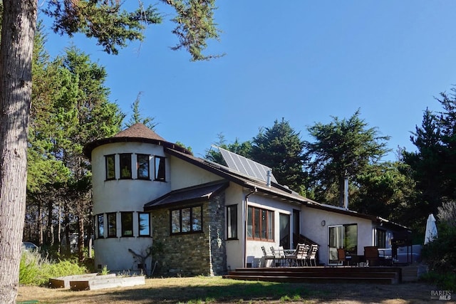 exterior space featuring solar panels and a wooden deck