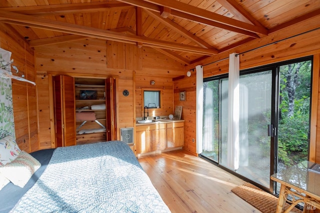 bedroom featuring sink, wood walls, wooden ceiling, light hardwood / wood-style flooring, and beam ceiling