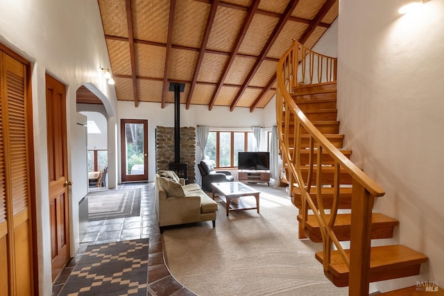 living room with carpet, a wood stove, high vaulted ceiling, wooden ceiling, and beam ceiling