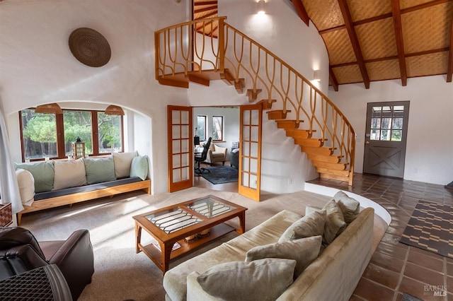 carpeted living room with beamed ceiling, wood ceiling, french doors, and high vaulted ceiling