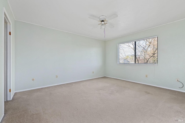 empty room with a ceiling fan, light carpet, and baseboards