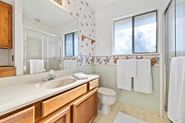 full bath featuring wallpapered walls, a stall shower, toilet, tile patterned floors, and vanity