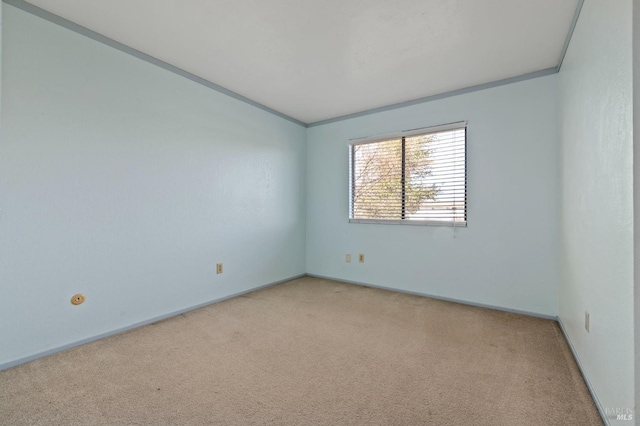 empty room with light carpet, baseboards, and ornamental molding