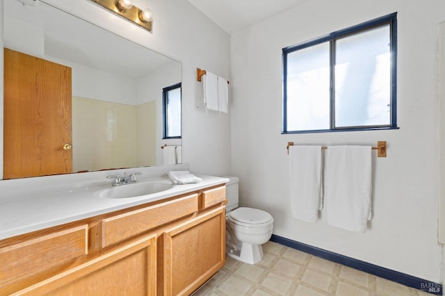 bathroom featuring baseboards, vanity, toilet, and tile patterned floors