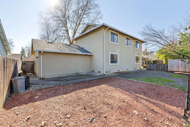 back of house featuring crawl space, a fenced backyard, roof with shingles, and a patio