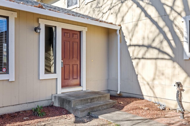 entrance to property featuring a shingled roof