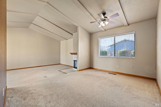 unfurnished living room with carpet floors, a fireplace, lofted ceiling with beams, and baseboards