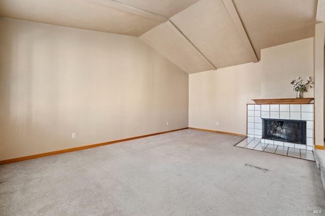 unfurnished living room with a tile fireplace, carpet, vaulted ceiling, and baseboards