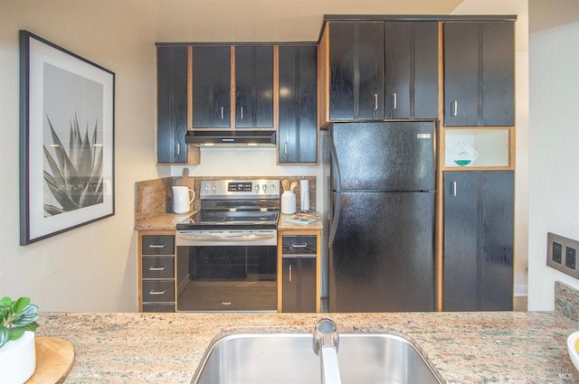 kitchen with black refrigerator, stainless steel electric stove, light stone countertops, and sink