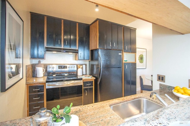 kitchen featuring black refrigerator, stainless steel range with electric stovetop, light stone countertops, and sink