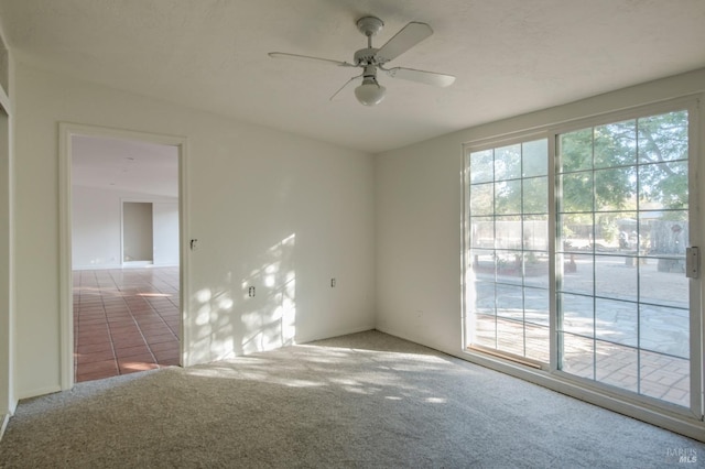 spare room featuring ceiling fan and light colored carpet