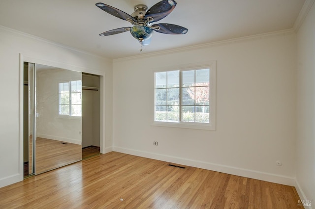 empty room with light hardwood / wood-style floors, crown molding, and ceiling fan