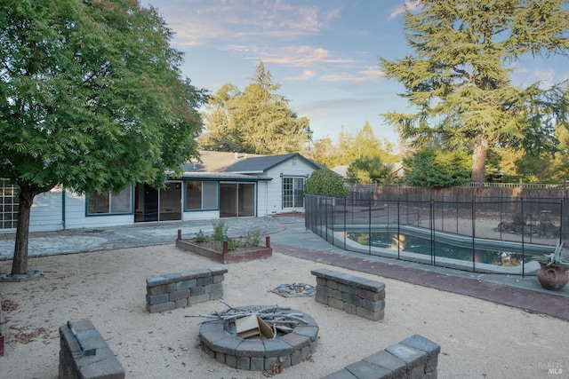 back of house featuring a patio area, an outdoor fire pit, and a fenced in pool