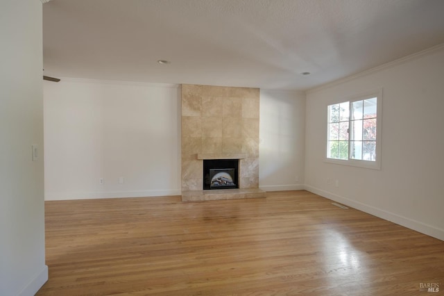 unfurnished living room featuring crown molding, light hardwood / wood-style floors, and a fireplace