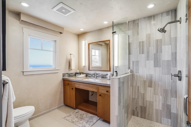 bathroom with a healthy amount of sunlight, a shower with door, and vanity