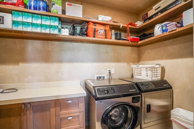 laundry room with washer and dryer and cabinets