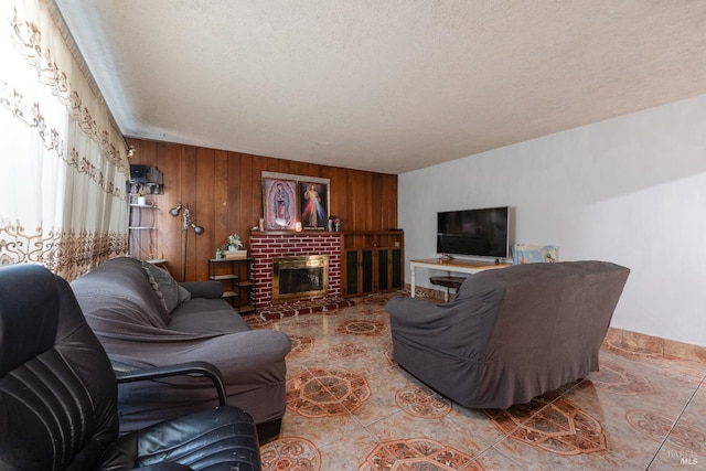 living area with wood walls, a fireplace, and a textured ceiling