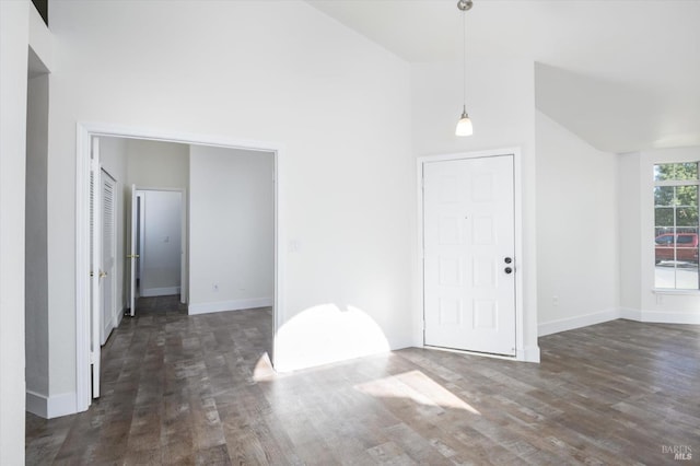 interior space with wood finished floors, high vaulted ceiling, and baseboards