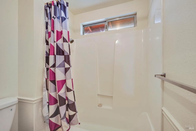 bathroom featuring toilet and a shower with shower curtain