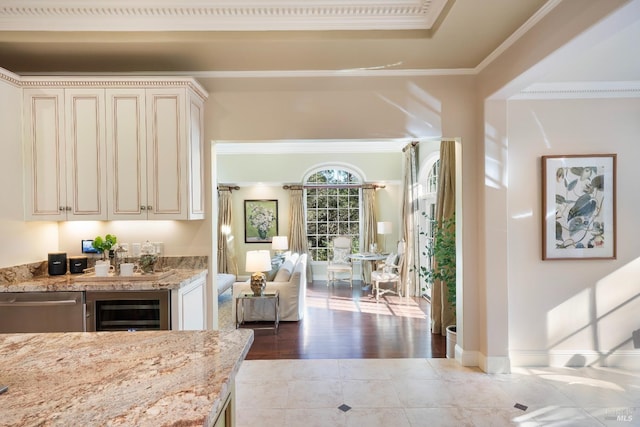 interior space featuring beverage cooler, baseboards, ornamental molding, tile patterned flooring, and stainless steel dishwasher