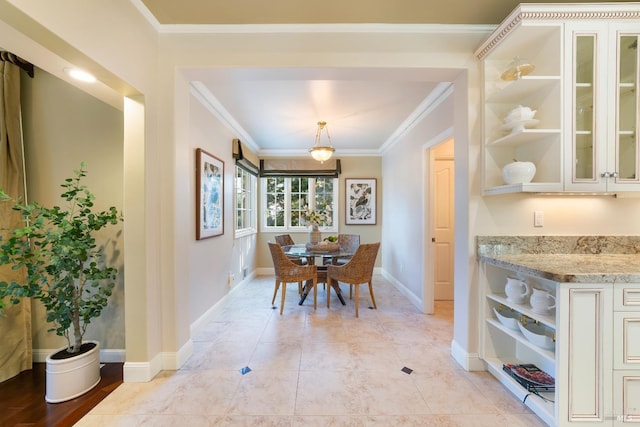 dining area featuring light tile patterned floors, ornamental molding, and baseboards