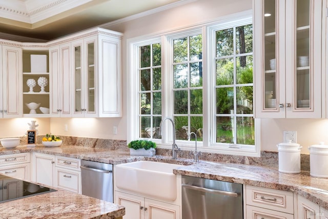 kitchen featuring stainless steel dishwasher, a sink, white cabinetry, and a healthy amount of sunlight