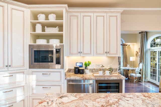 kitchen featuring wine cooler, cream cabinetry, stainless steel appliances, ornamental molding, and light stone countertops