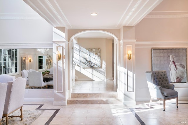 tiled entryway featuring baseboards, arched walkways, and ornamental molding