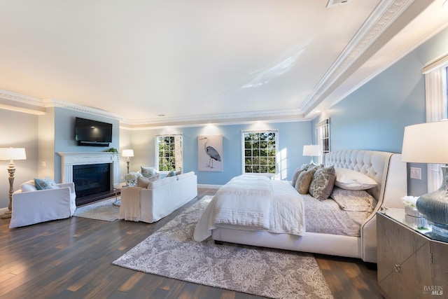 bedroom featuring ornamental molding, dark wood-type flooring, and a fireplace